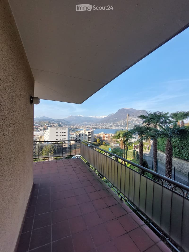 Balcony with tiled floor, metal railing, and a view of the city and mountains