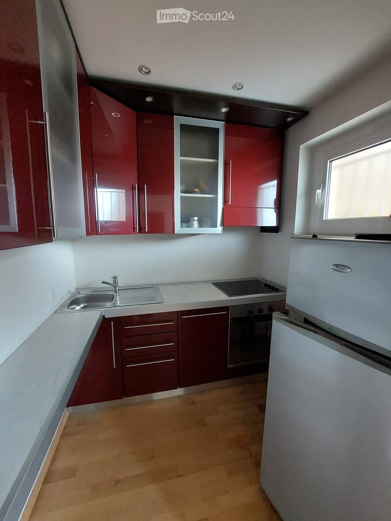 modern kitchen with red cabinets, granite countertop, stainless steel sink, gas stove, dishwasher, refrigerator
