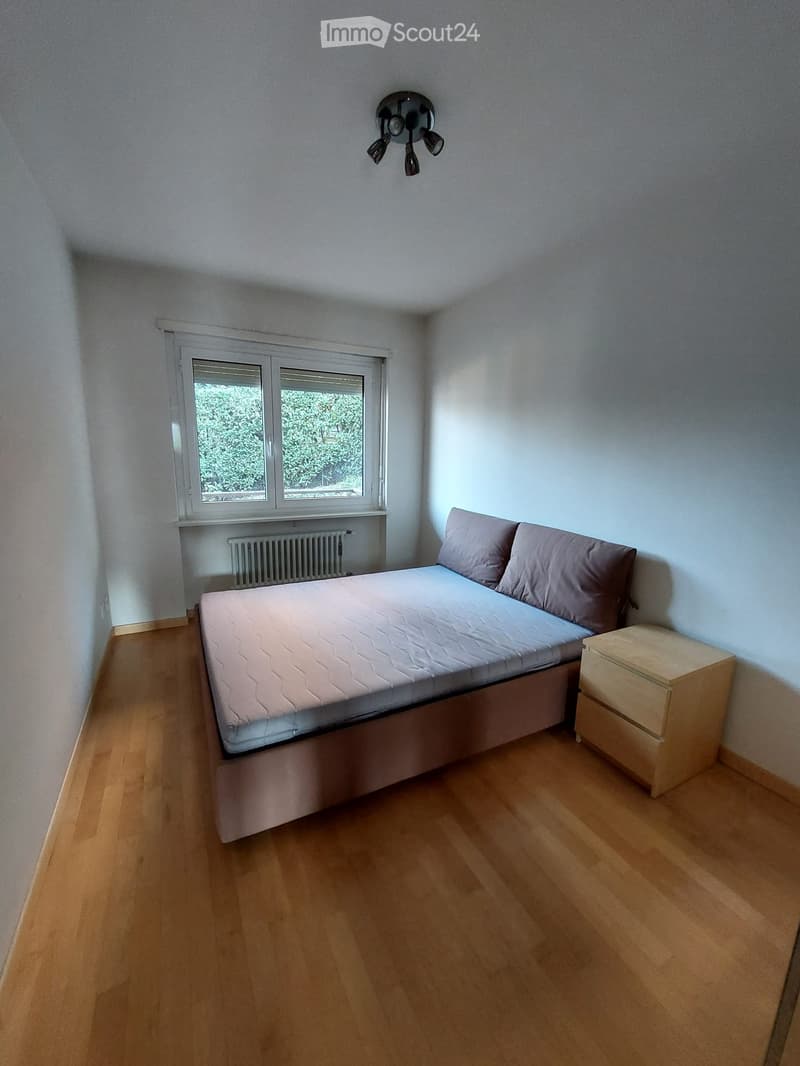 Bedroom with bed, nightstand, and window with blinds