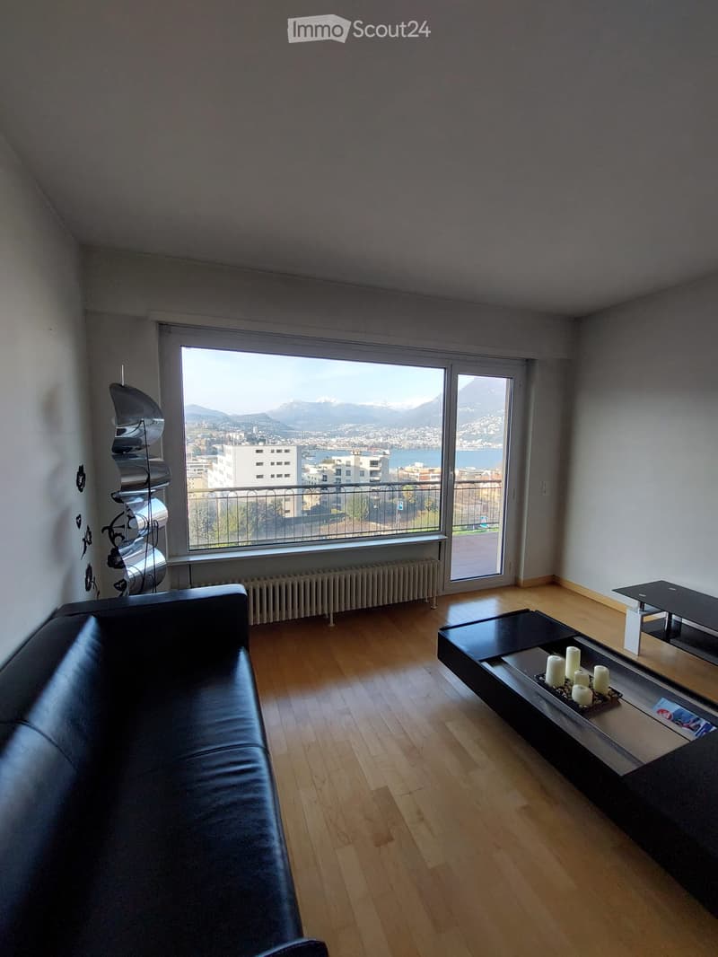 modern living room, black leather couch, wooden floor, large windows, balcony, city view