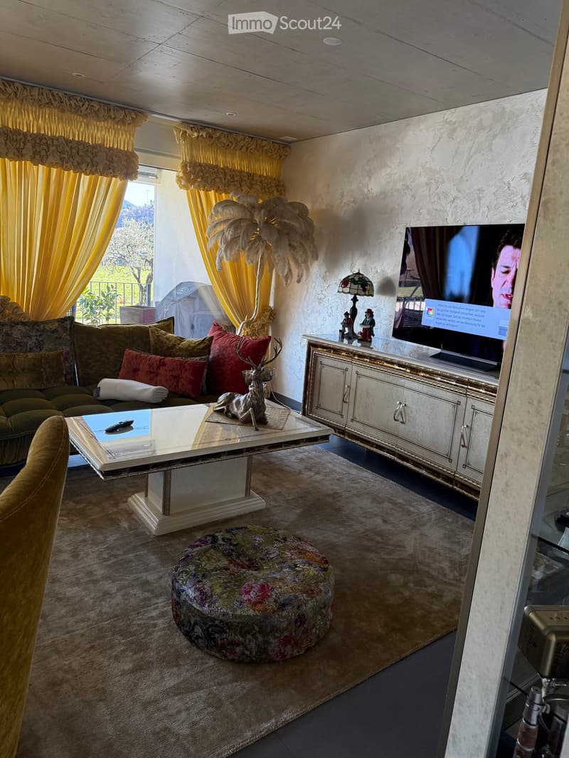 living room with couch, coffee table, TV, carpet, decorative items, large windows