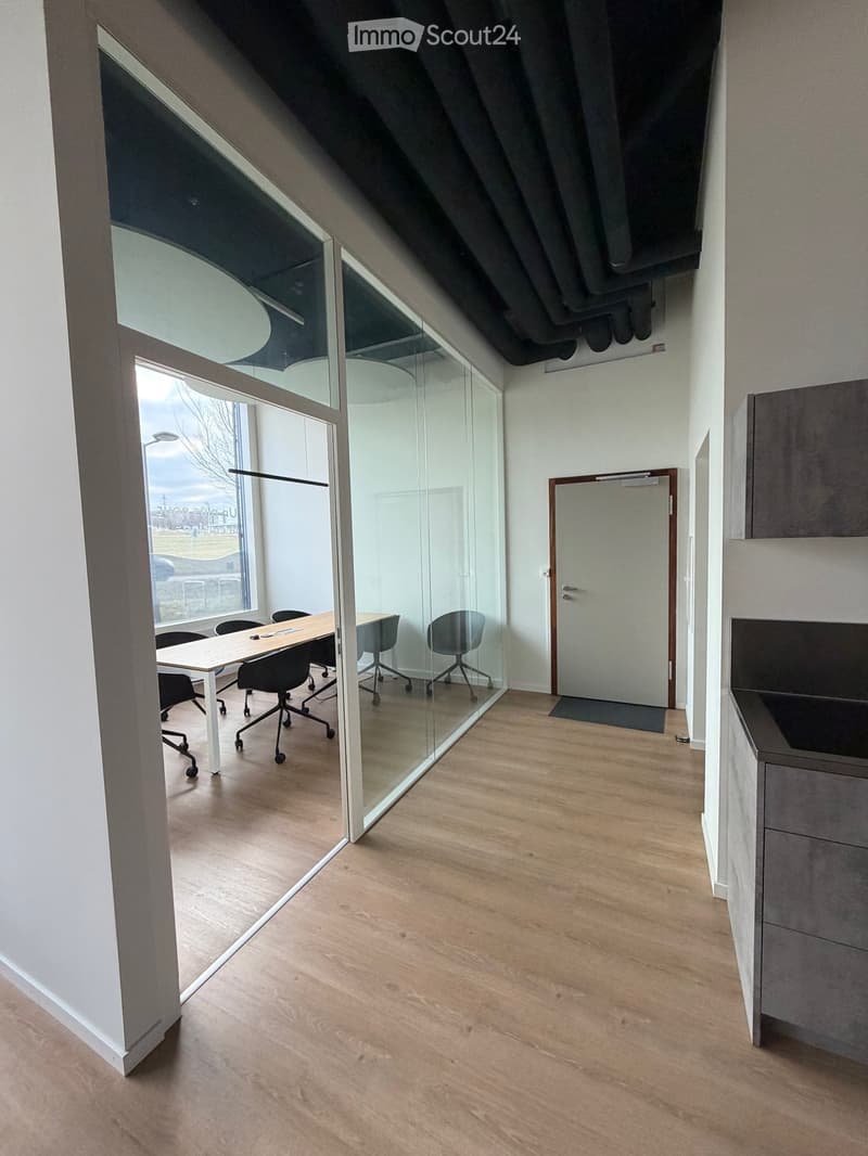 office space with glass walls, large windows, wooden floor, office table, chairs, cupboard, sink
