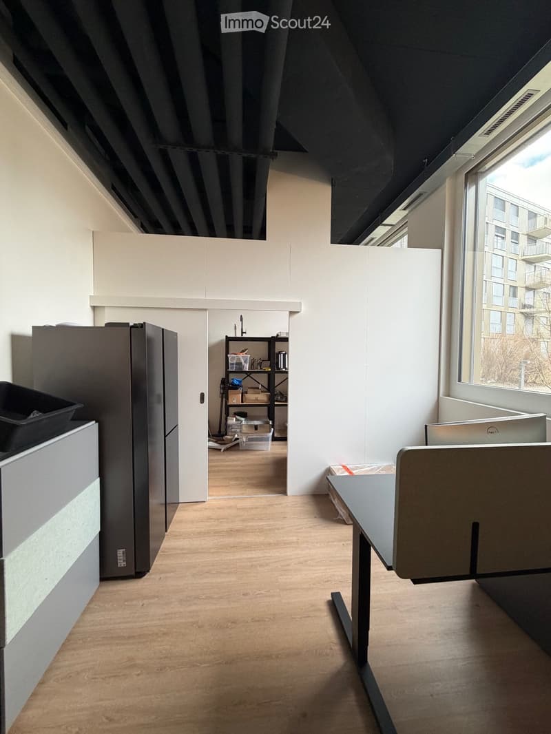 empty room with desk, office equipment and refrigerators, wooden floor, large window, ceiling with lighting
