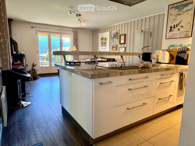 modern kitchen with granite countertop, white cabinets, stainless steel sink, faucet, and a view of the mountains
