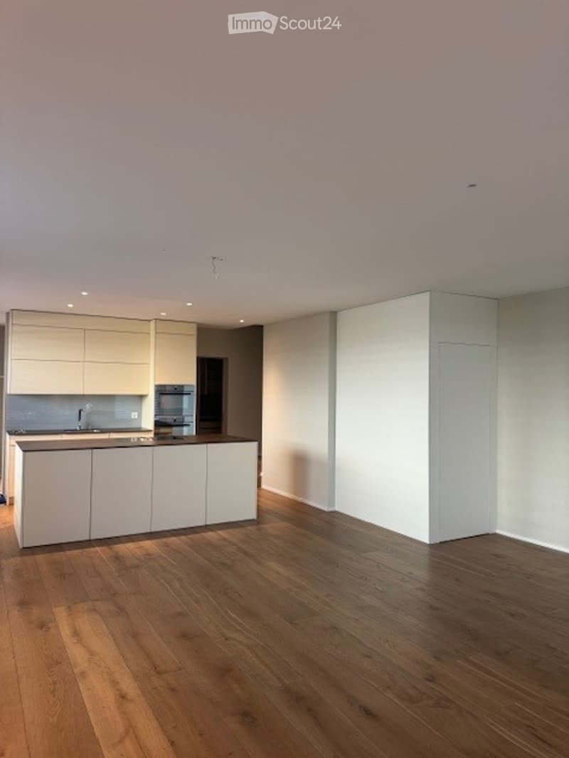 modern kitchen with wooden floor, white cabinets, island countertop, stainless steel appliances, and a sink with a faucet
