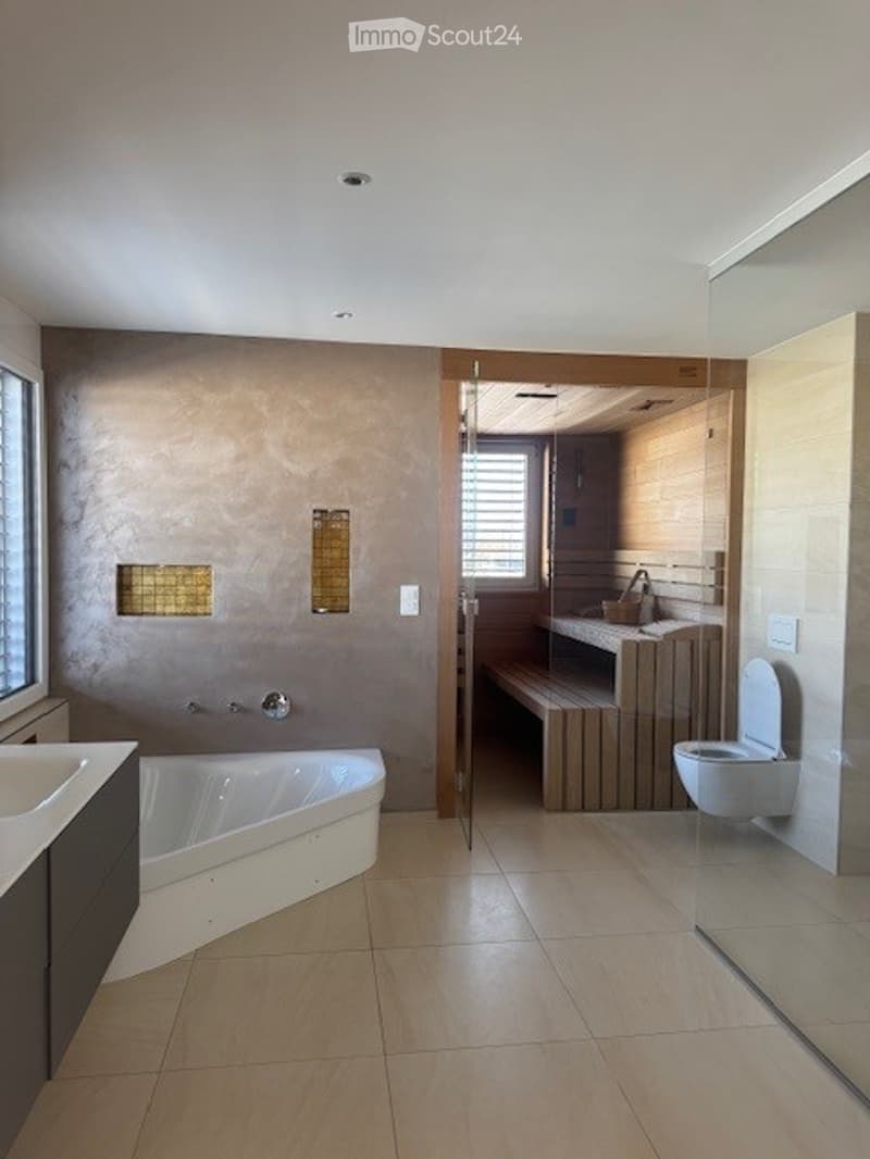 modern bathroom with bathtub, wooden bench, toilet, sink, and glass door