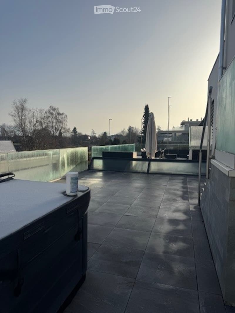 Rooftop with a swimming pool, glass railings, and a hot tub