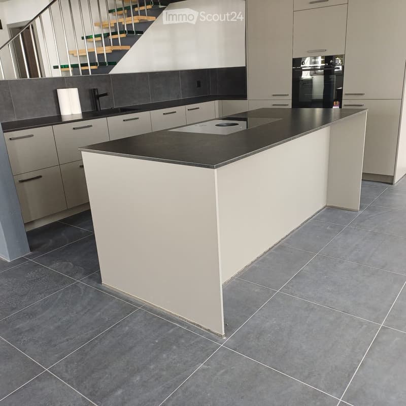 modern kitchen with island, black countertops, white cabinets, tiled floor, stainless steel faucet, built-in oven