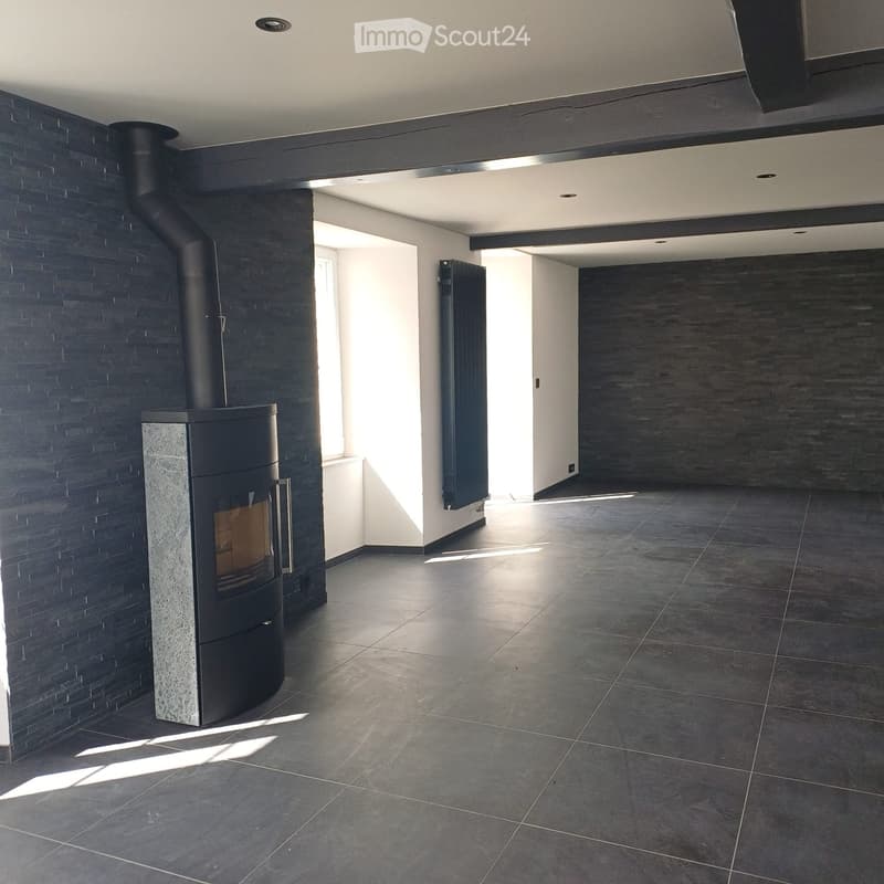 Empty room with fireplace, black tiled floor, black brick wall, white walls, window