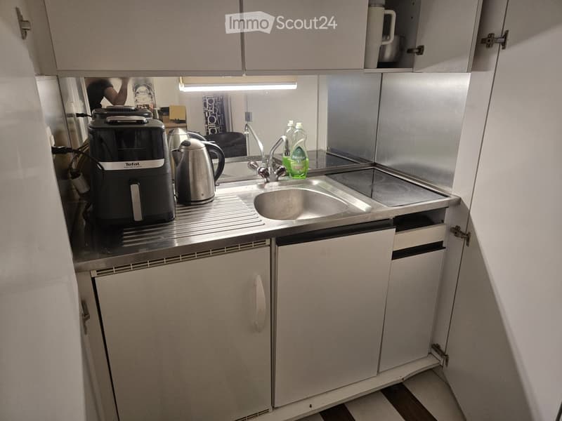 stainless steel countertop, sink, electric kettle, coffee machine, dishwashing machine, cabinets, mirror