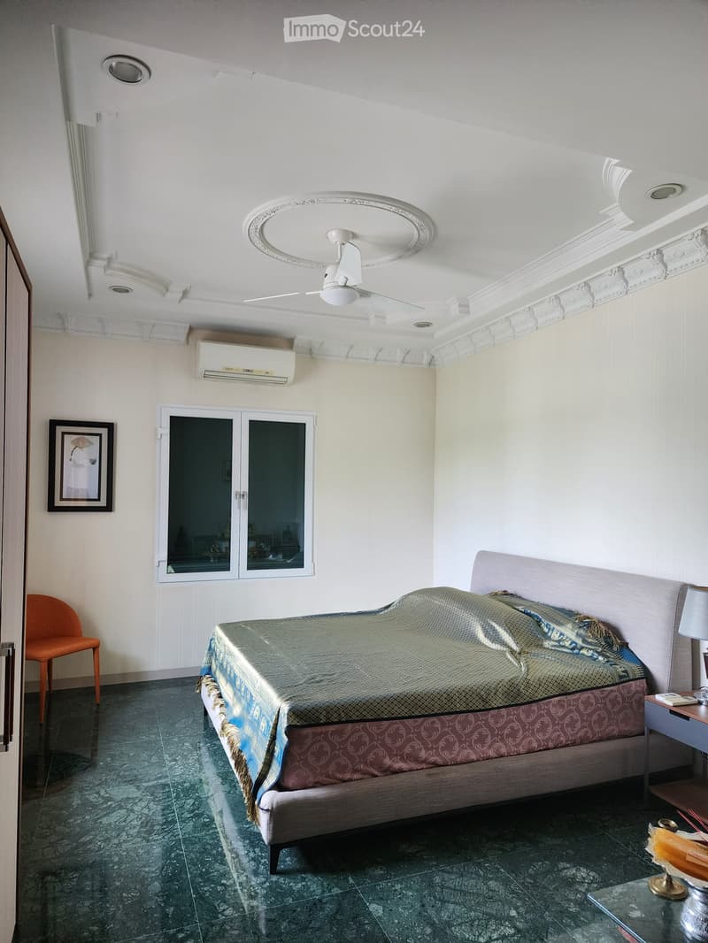 Bedroom with bed, chair, picture frame, window, air conditioner, ceiling fan, nightstand, lamp, table, and tiled floor.