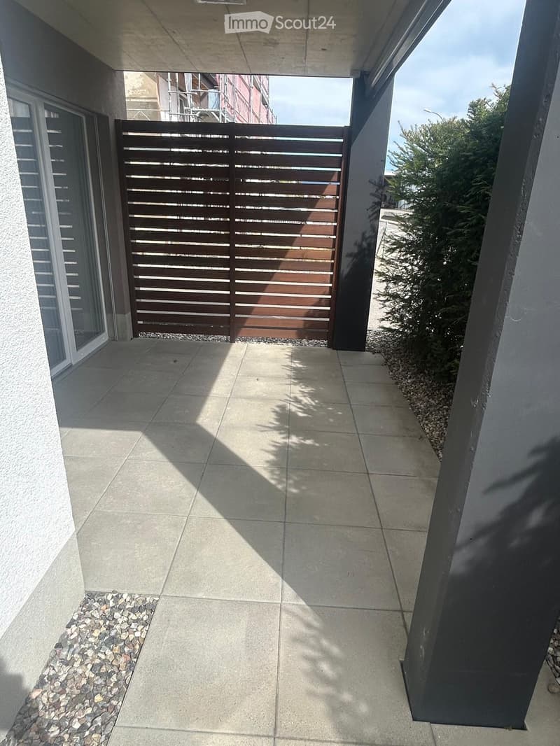 Entrance area with wooden gate, tiled floor, and gravel pathway