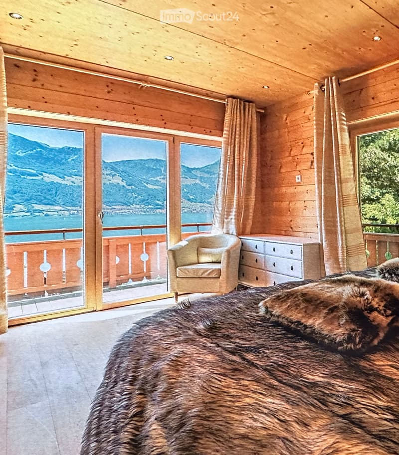 Large wooden wall, chair, windows, fluffy furs, panoramic view of mountains