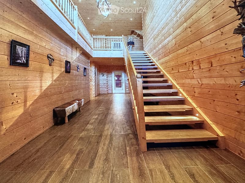 interior with wooden walls and floors, staircase with wooden handrail, wooden flooring with lights, ceiling with decorative items
