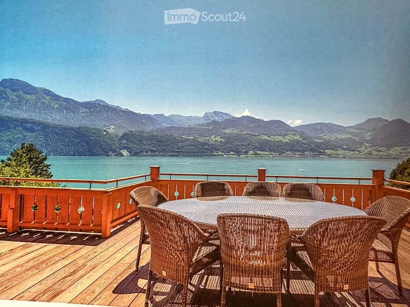 round table and chairs on wooden terrace, stunning mountain and lake view