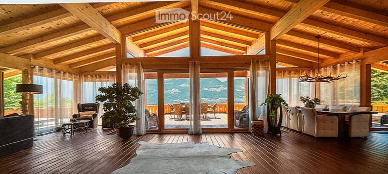 interior features wooden ceiling, large glass windows, wood flooring, dining area with chairs and table, plants and lamps
