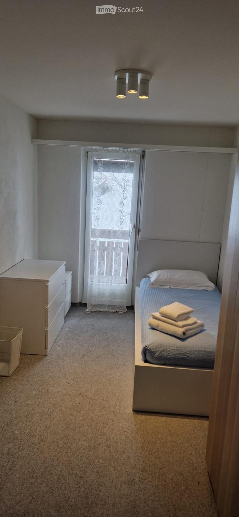 single bed, white cabinet, white curtains, balcony