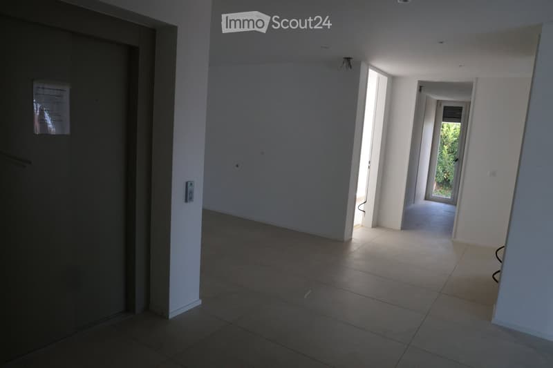 Empty hallway with tiled floor, white walls, and open doors leading to other rooms.