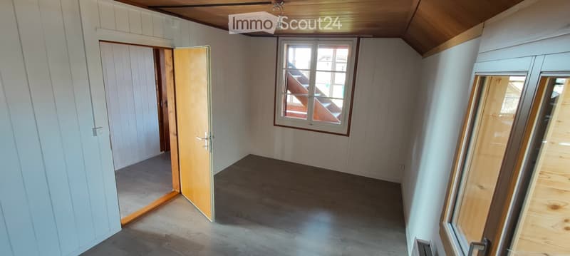 empty room, wooden ceiling, wooden floor, white walls, two windows, open door