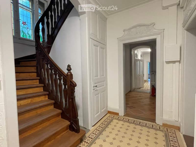 Wooden staircase, white walls, wooden floor, white doors, stained glass window, carpet