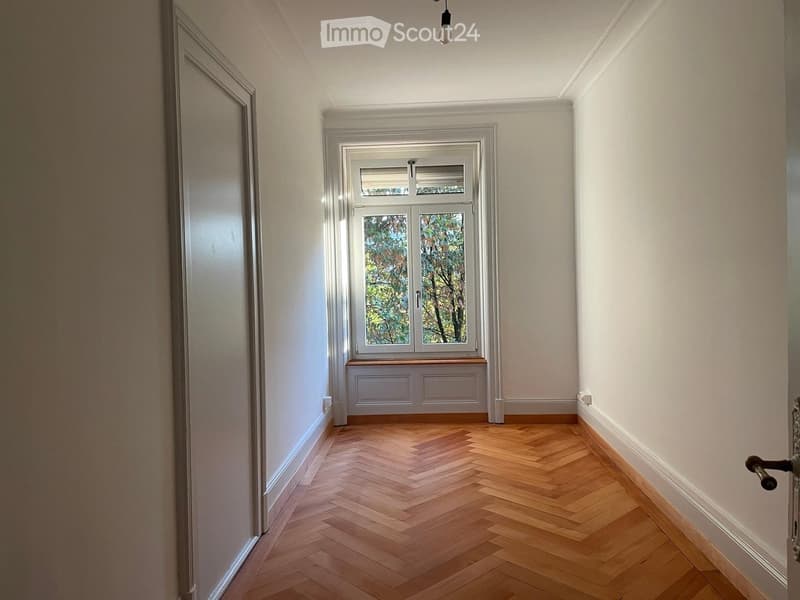 empty room, wooden parquet floor, white walls, window with view of trees, window seat