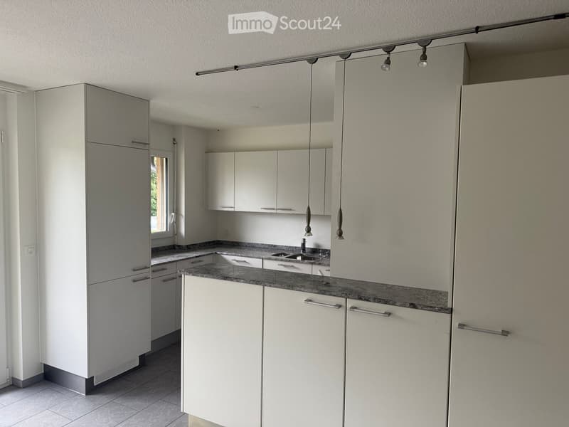 modern kitchen with white cabinets, granite countertops, stainless steel sink, and a window