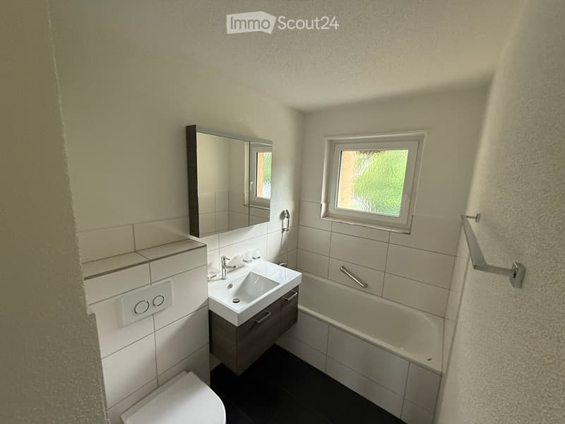 Bathroom with white tiles, white sink, white bathtub, white toilet, mirror, window