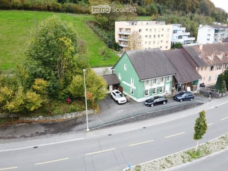Building with green facade, cars parked outside, residential area