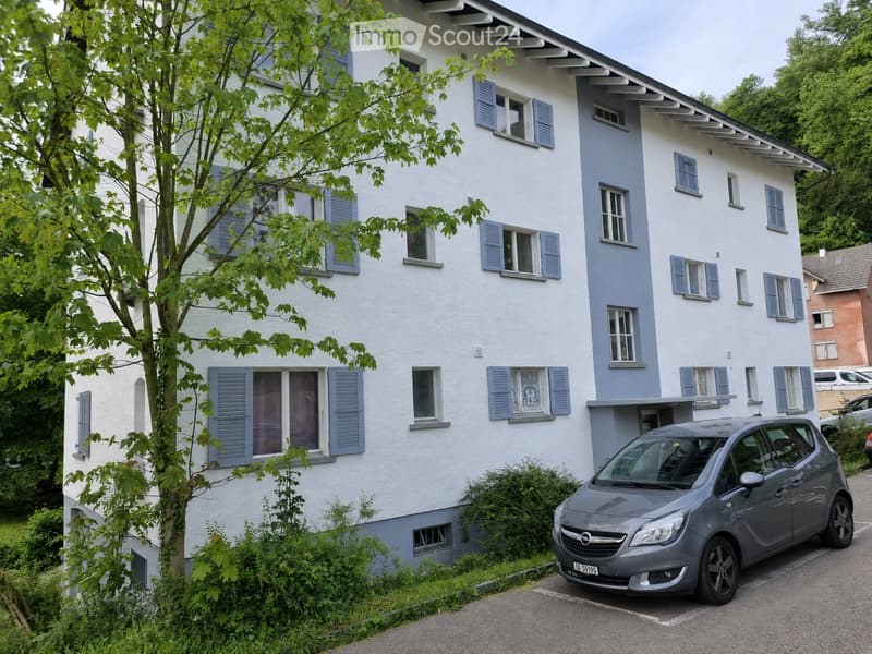 House. Two-story house with white and blue exterior, multiple windows with shutters, and a parked car in the driveway.