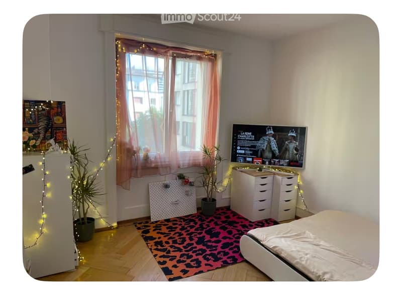 Bedroom with bed, rug, plants, TV, and string lights
