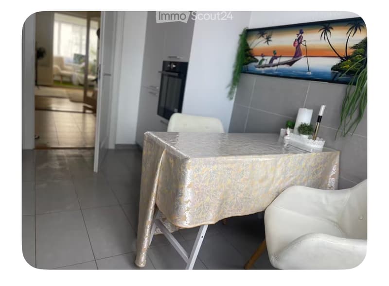 Dining room with a table, chairs, and a painting on the wall