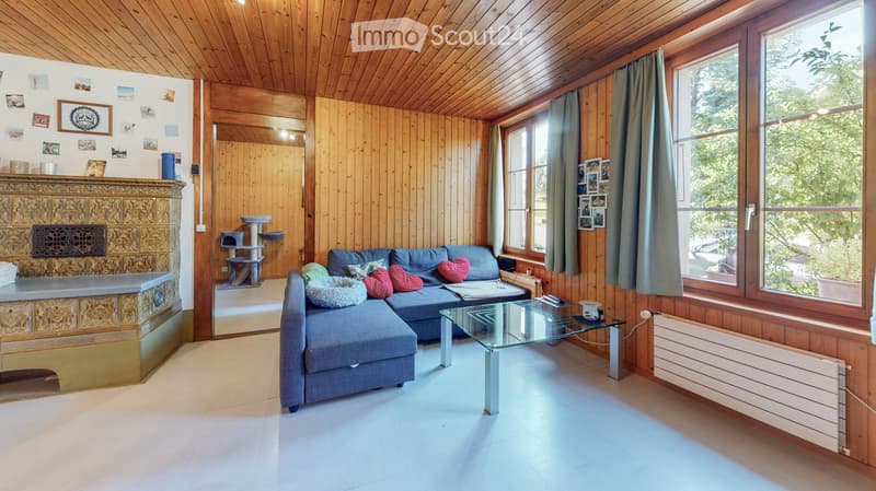 wooden walls, fireplace, blue sofa, glass table, large windows