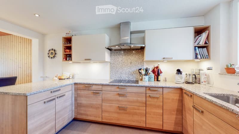 modern kitchen with wooden cabinets, granite countertops, stainless steel appliances, and a large window