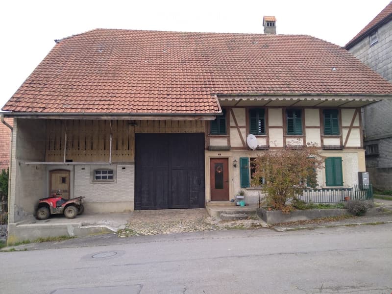 2 story house, red roof, brick walls, wooden garage, windows with green shutters, satellite dish