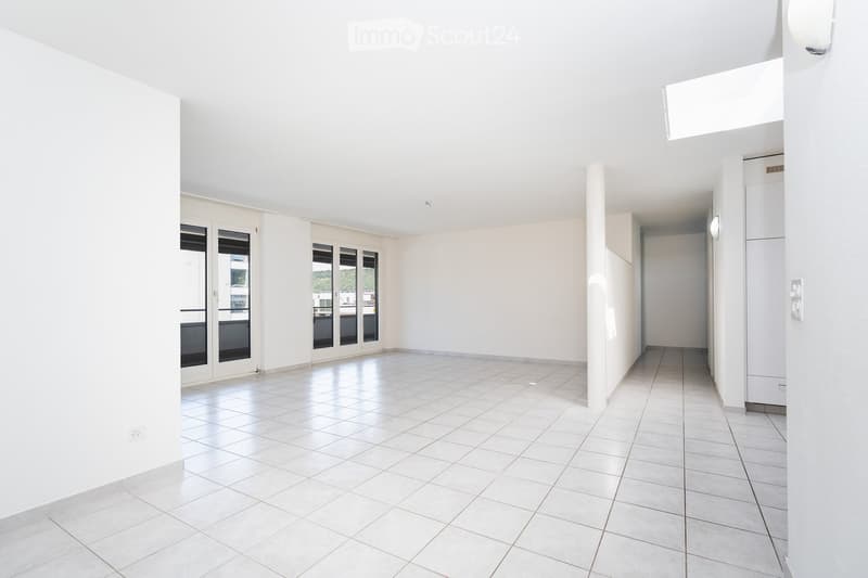 Empty room with white tiled flooring, white walls, large windows, and a door leading to an outdoor area.