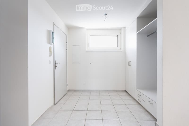 Empty room with white walls, tiled floor, built-in closet with drawers, and a window. No furniture or personal items present.