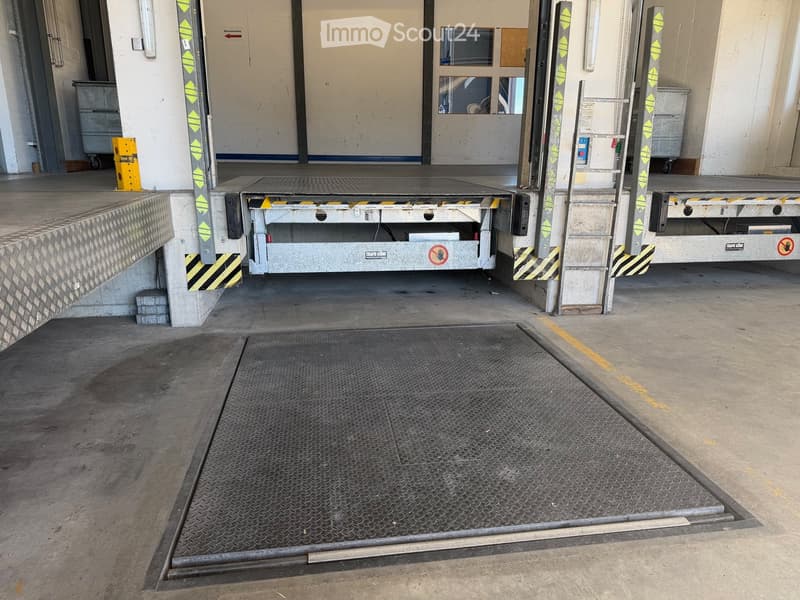 elevator platform, metal grate, yellow line, ladder, metal pillars