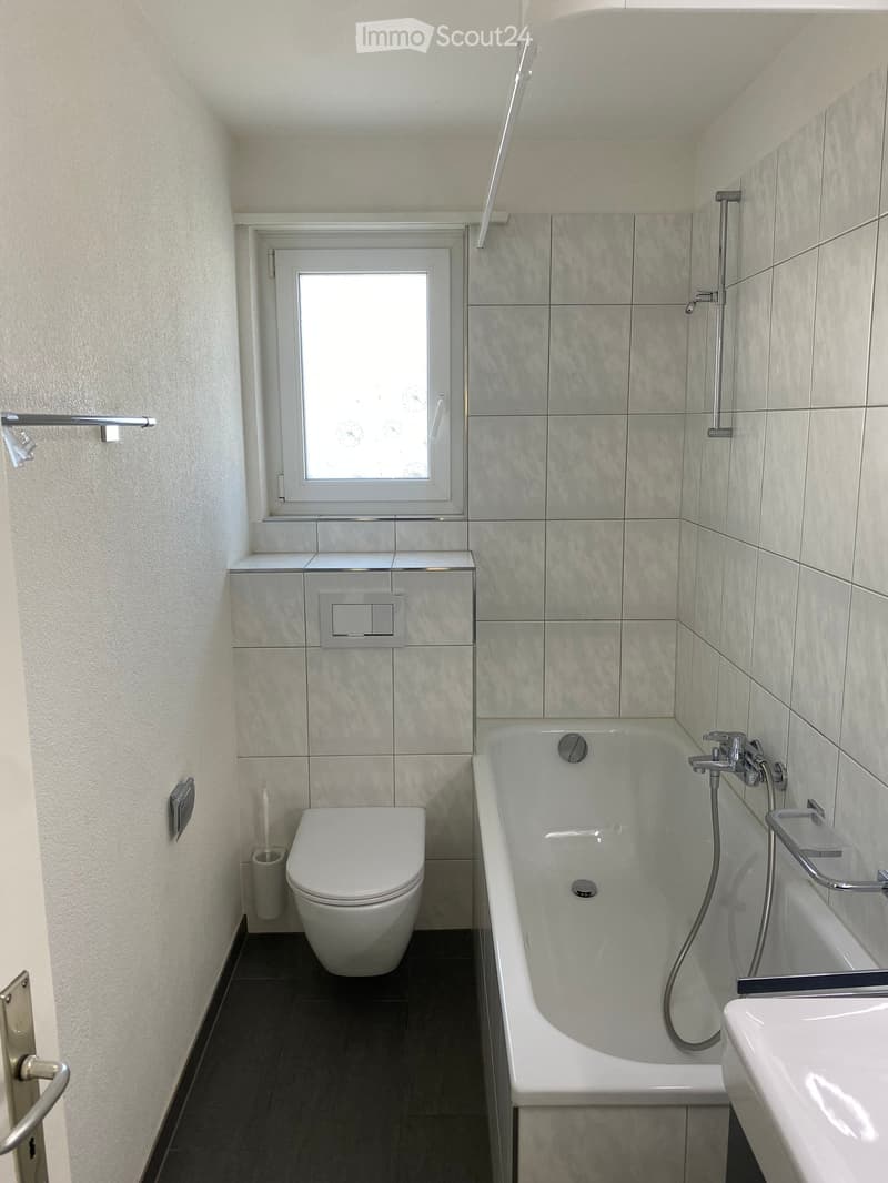 white tiles, white bathtub, white toilet, white sink, window
