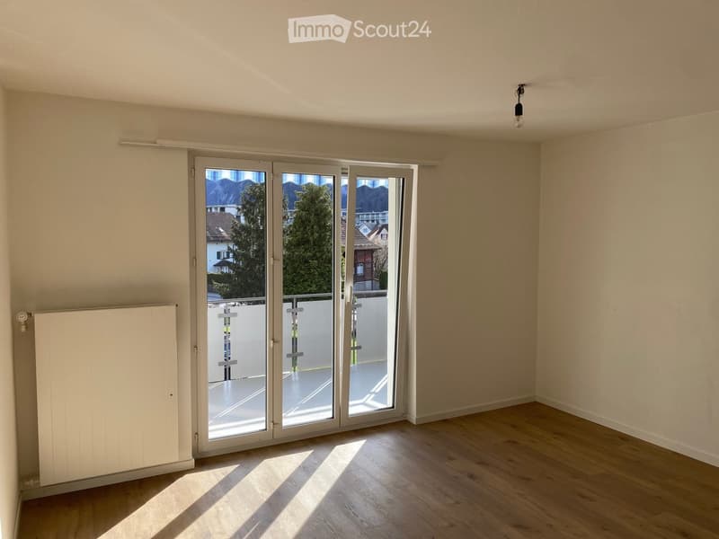empty room, wooden floor, sliding glass doors, balcony, white walls, radiator