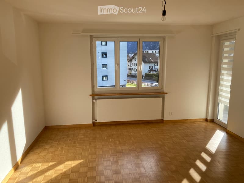 empty room, wooden floor, white walls, large window, heater under window, sliding door