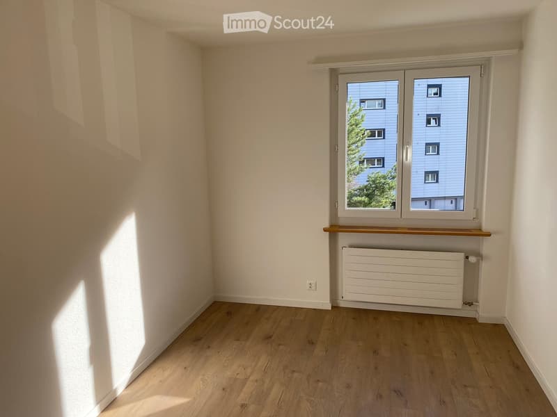 empty room, white walls, wooden floor, white radiator, window with view