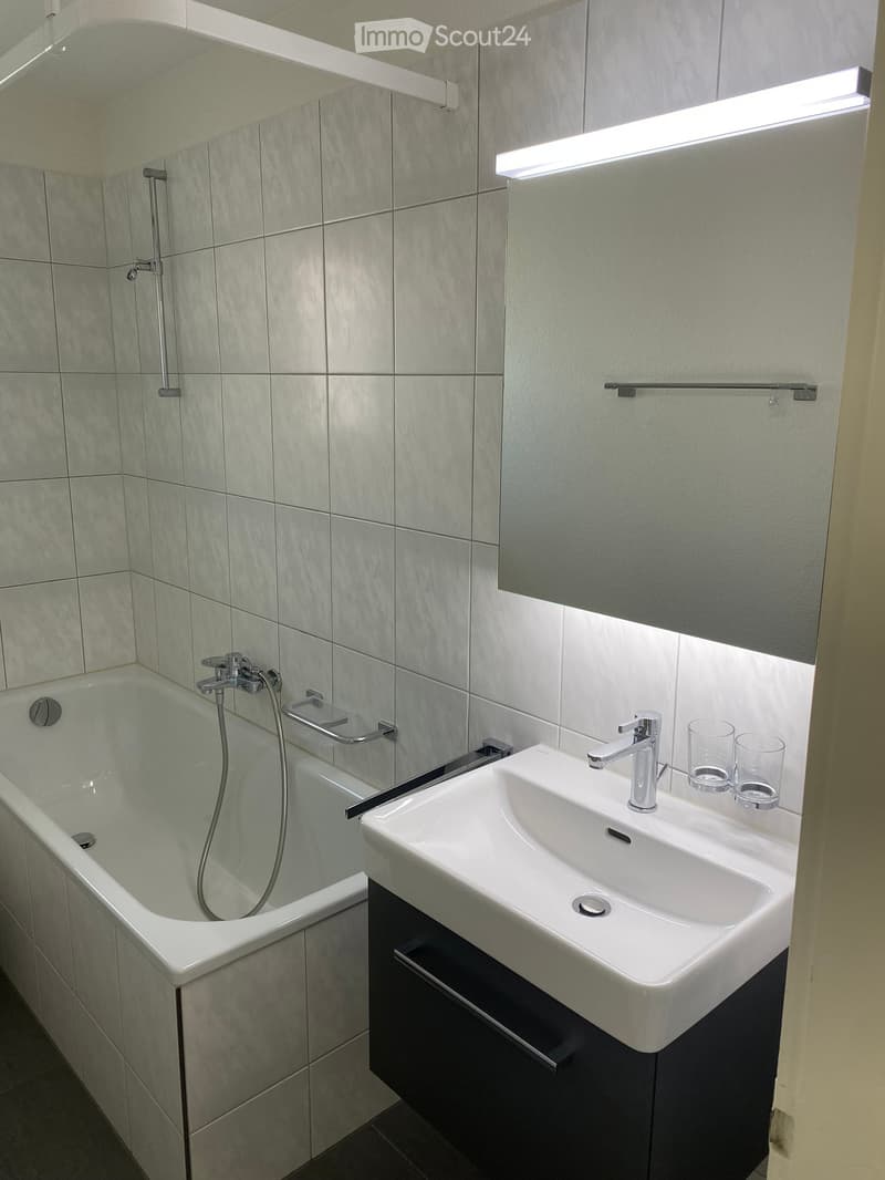 Bathroom with bathtub, sink, mirror, and shower head