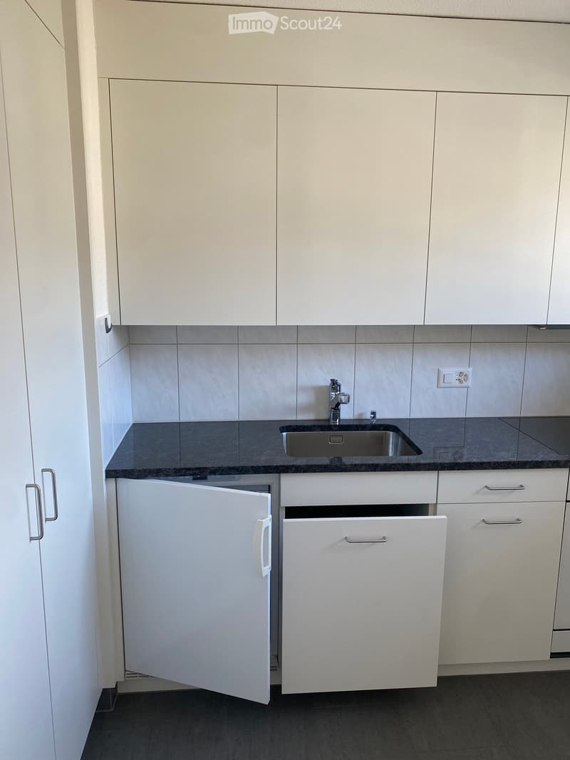 modern kitchen with white cabinets, granite countertop, stainless steel sink, and a dishwasher