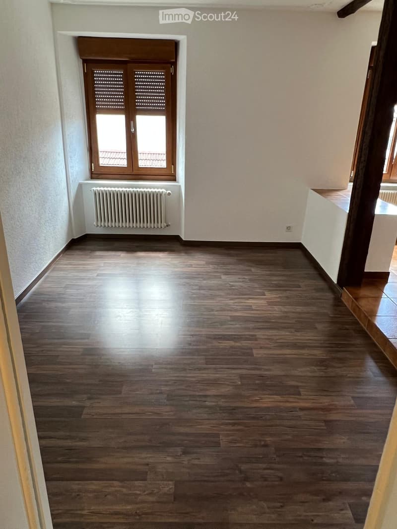 empty room, wooden floor, white walls, window with shutters, radiator