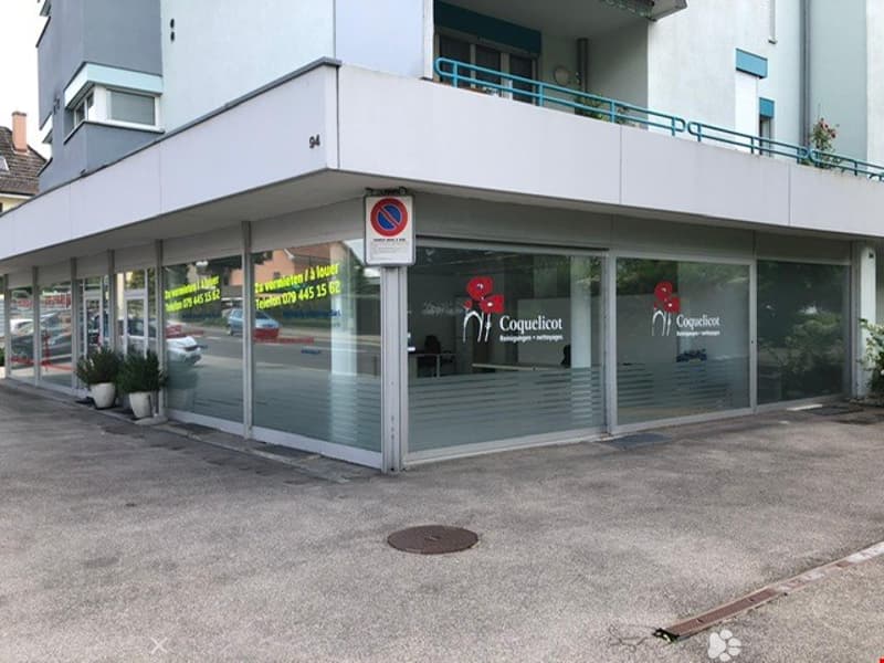 Modern building with glass facade, balcony, and signboard