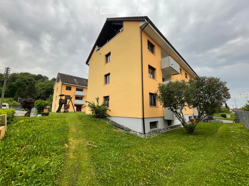 2 story yellow house, white trim, multiple balconies, large grassy yard