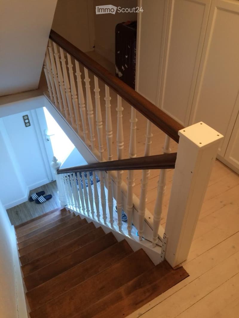 wooden staircase with white handrail and brown wooden steps