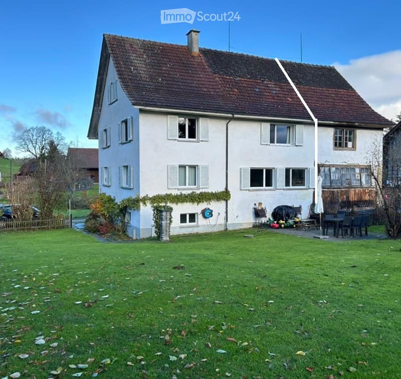 2 story house, white exterior, brown roof, multiple windows, balcony, garden, outdoor seating