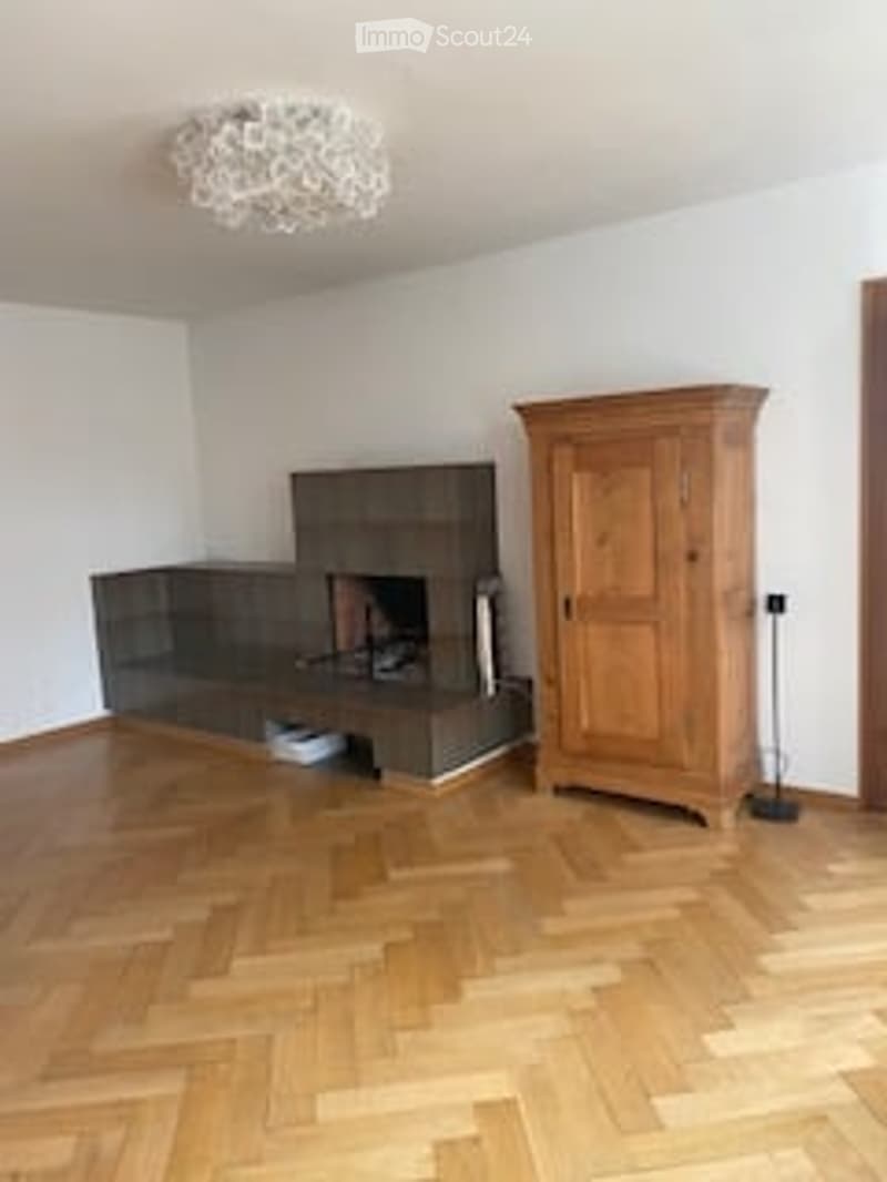 wooden floor, fireplace, white walls, wooden cabinet, chandelier