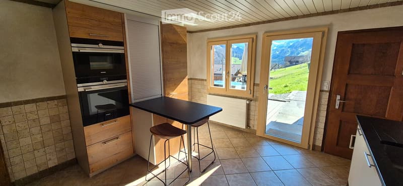 kitchen with oven, table, chairs, tiled floor, sliding door, view of mountains